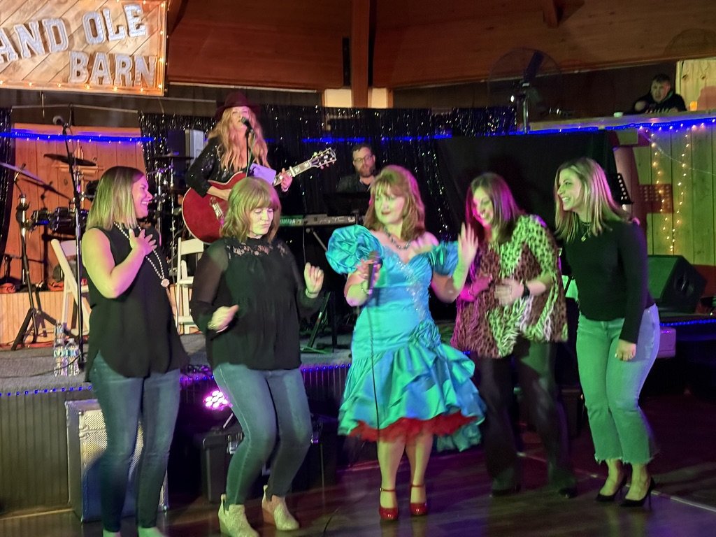 Fans dancing on stage at the Grand Ole Barn
